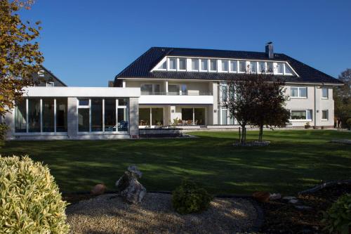 a house with a dog sitting in front of it at Hotel Am Friesenstrand in Butjadingen