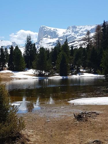 a lake with snow capped mountains in the background at Le p'tit Cozy in Le Dévoluy