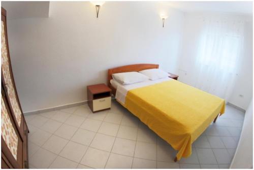 - une chambre avec un lit et une couverture jaune dans l'établissement Ferienwohnung Neele - Wohnung 1, à Krnica