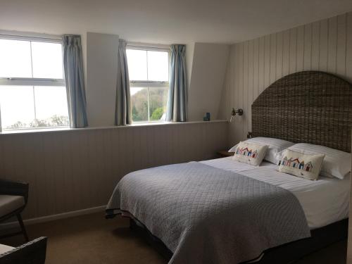 a bedroom with a large bed with two pillows at Woodlands Guest House in Saundersfoot