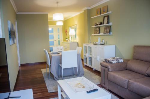 a living room with a couch and a dining room at Apartamento céntrico y tranquilo en Santiago de Compostela in Santiago de Compostela