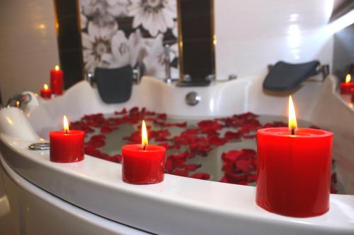 Tre candele rosse davanti a una torta con delle rose di Hotel La Mansion a Tacna