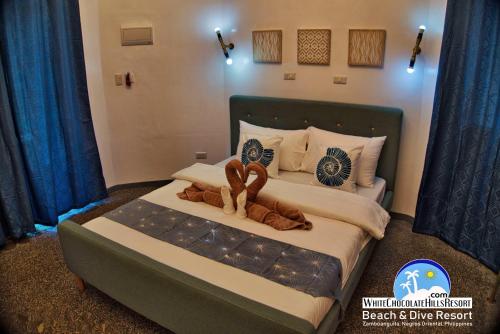 a bedroom with a bed with two stuffed animals on it at White Chocolate Hills Resort in Zamboanguita