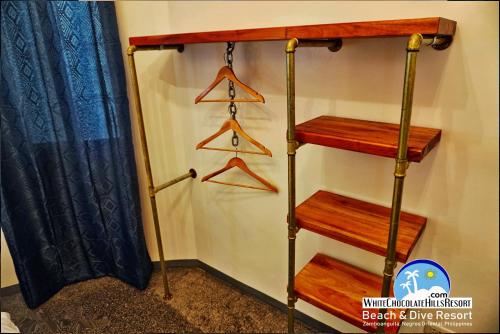 a shelf in a room with wooden hangers at White Chocolate Hills Resort in Zamboanguita