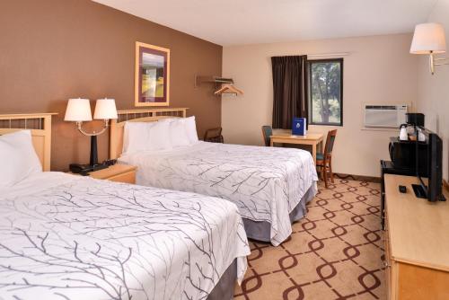 een hotelkamer met 2 bedden en een televisie bij Cottonwood Inn and Conference Center in South Sioux City