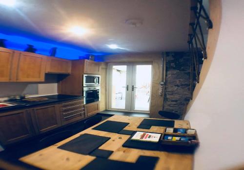una cocina con una mesa de madera y una luz azul en Ayrshire Holiday Cottage en Girvan