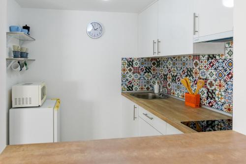 - une cuisine avec un évier et un mur en carrelage dans l'établissement Apartamento turístico en Brunete, à Brunete