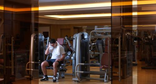 a man sitting on a chair in a gym at Four Seasons Hotel Baku in Baku