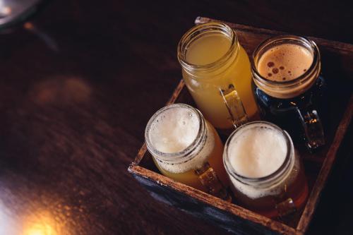 a wooden tray with four glasses of beer on a table at enVision Hotel Miami International Airport in Miami