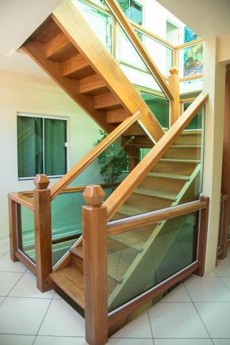 a wooden staircase with glass treads in a building at Pousada Belezinha in Arraial do Cabo