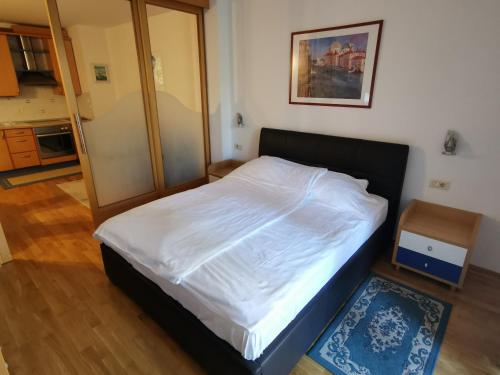 um quarto com uma cama com lençóis brancos em Apartment Brinovec em Portorož