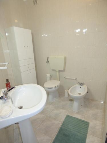 a bathroom with a white sink and a toilet at Milfontes Paradise in Vila Nova de Milfontes