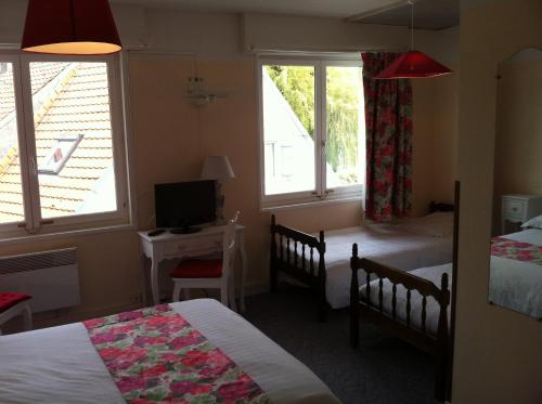 a bedroom with two beds and a television and two windows at Hôtel Le Vivier WISSANT - Centre Village - Côte d'Opale - Baie de Wissant - 2CAPS in Wissant