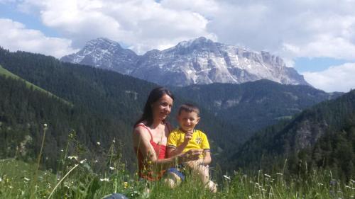 a woman and a child sitting on a mountain at Chalet Morin in San Martino in Badia