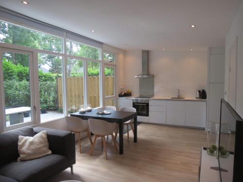 a kitchen and living room with a table and chairs at 't Salehemse Huuske in Zelhem
