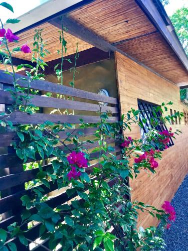 a wooden dog house with pink flowers on it at Oleadas Maderas in San Juan del Sur