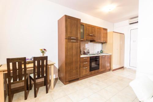 a kitchen with wooden cabinets and a table with chairs at Lindos Blue Sky in Líndos
