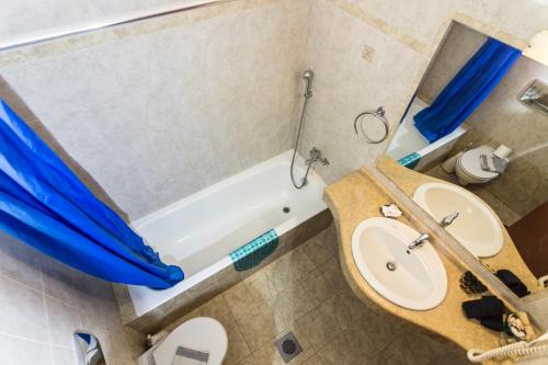 a bathroom with a tub and a sink and a toilet at Lindos Blue Sky in Líndos