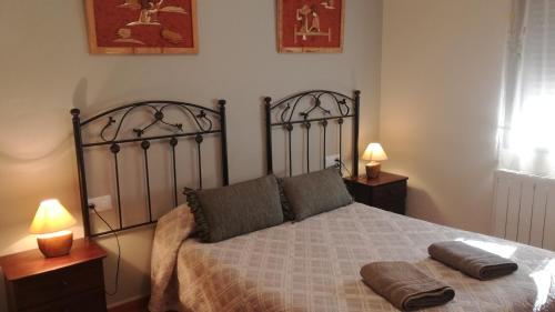 een slaapkamer met een bed met 2 kussens erop bij Apartamentos Rurales Carlos in Barracas
