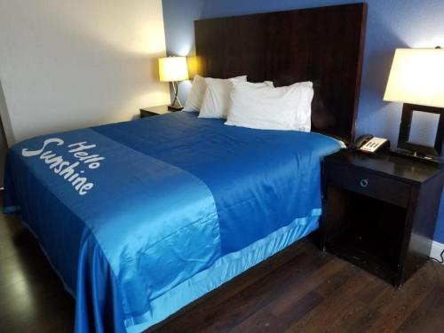 a bed with a blue comforter in a hotel room at Days Inn by Wyndham Thomson in Thomson