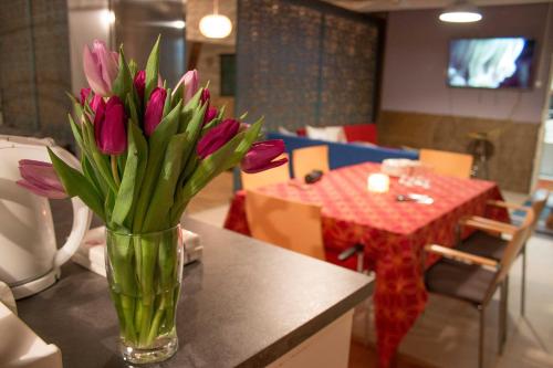eine Vase voller rosa Tulpen auf einem Tisch in der Unterkunft Mixed colors loft -majoitus in Lahti