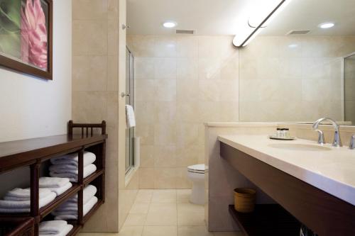 a bathroom with a toilet, sink, and bathtub at Lotus Honolulu at Diamond Head in Honolulu