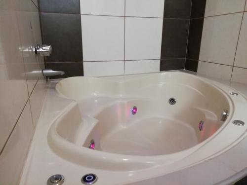 a white tub in a bathroom with a tiled wall at Madison Suite in Tacna