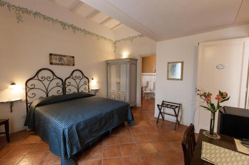 1 dormitorio con 1 cama con colcha azul en Hotel Locanda Degli Artisti, en Borgo San Lorenzo