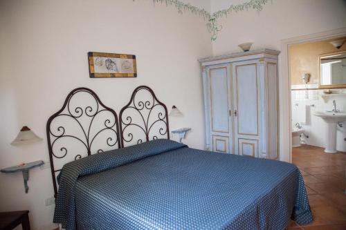 a bedroom with a bed with a blue blanket at Hotel Locanda Degli Artisti in Borgo San Lorenzo