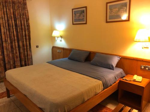 a bedroom with a bed with two pillows on it at Maple Leaf Korean Hotel in Accra