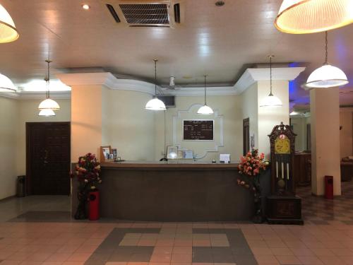 a restaurant with a bar with a clock and lights at Maple Leaf Korean Hotel in Accra