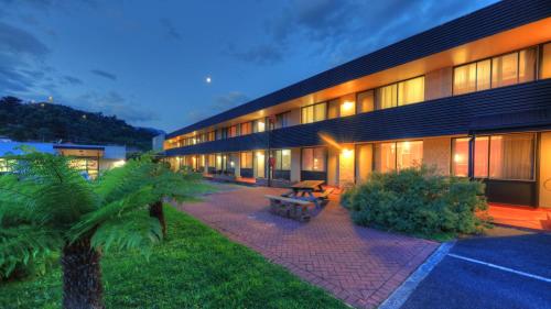 ein Gebäude mit einer Picknickbank davor in der Unterkunft Queenstown Motor Lodge in Queenstown