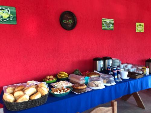 a table with many different types of bread and other foods at Pousada Recanto dos Maximianos in Jarinu