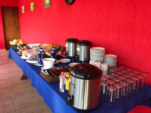a table with a blue table cloth with food and drinks at Pousada Recanto dos Maximianos in Jarinu
