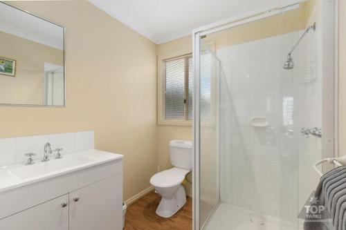 a bathroom with a toilet and a glass shower at Yarram Holiday Park in Yarram