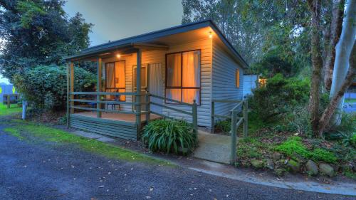 a tiny house with a porch on a street at Yarram Holiday Park in Yarram