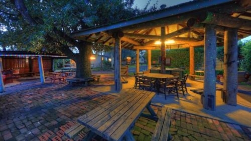 a wooden pavilion with a table and chairs under a tree at Yarram Holiday Park in Yarram