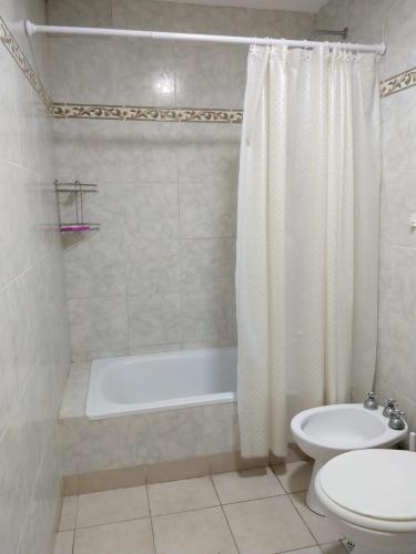 a bathroom with a tub and a toilet and a sink at Avellaneda 1247 in Tandil