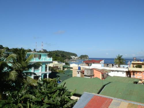 a view of a city with houses and the ocean at The Blue Pagong in Puerto Galera