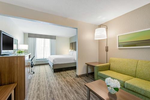 een hotelkamer met een bank en een bed bij Holiday Inn Melbourne-Viera Conference Ctr, an IHG Hotel in Melbourne