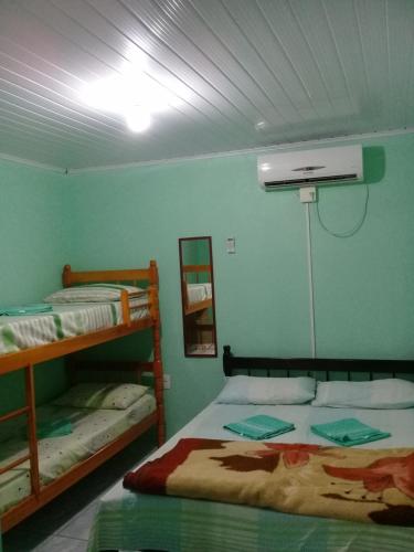 a bedroom with two bunk beds and a fan at Pousada Cabral in São Gabriel