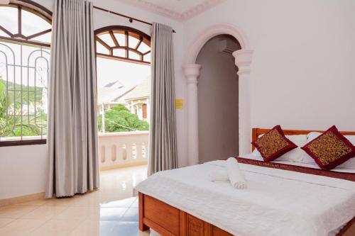a bedroom with a bed and a large window at Rio 6a homestay in Vung Tau