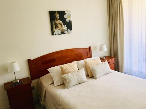 1 dormitorio con 1 cama blanca grande y 2 lámparas en Aconcagua Apartments, en Santiago