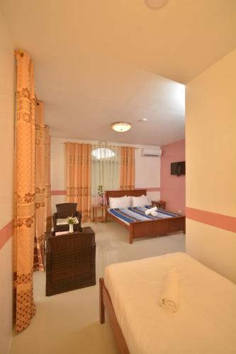 a hotel room with a bed and a couch at White Summerville Tourist Inn in Busuanga