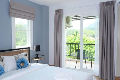 een slaapkamer met een bed en een balkon bij Living at Sphere Apartment in Ao Nang Beach