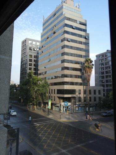 un gran edificio con una palmera frente a una calle en Austral Rentahome Barros Borgoño, en Santiago