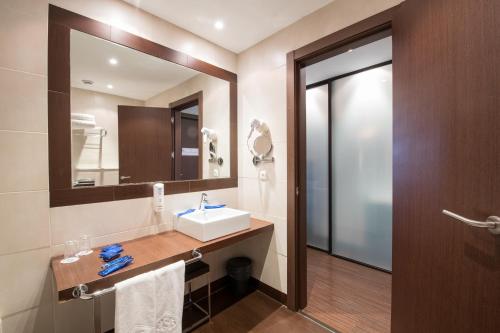 a bathroom with a sink and a mirror at ARVA Abad San Antonio in León