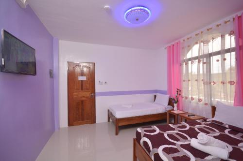 a bedroom with a bed and a window and a bed sidx sidx sidx at White Summerville Tourist Inn in Busuanga