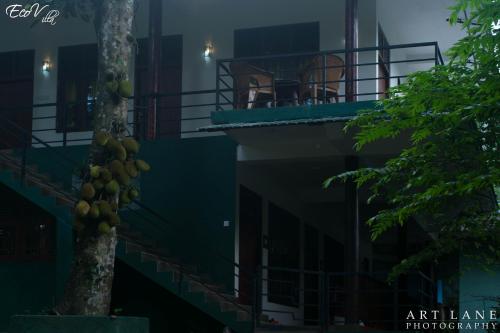 a building with a bunch of fruit hanging from a tree at Eco Villa - Sinharaja in Deniyaya