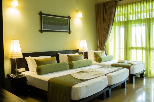 a hotel room with two beds and two lamps at Oak Ray Wild Yala in Tissamaharama